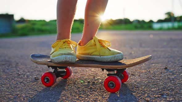 Close Up of Child Foot in Sneaker on Skateboard in Motion Boy Skater Riding at Sunset