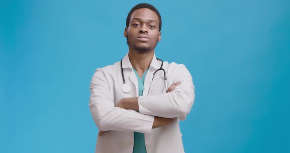 Studio Portrait of Serious Confident African American Doctor Crossing His Arms and Nodding To Camera