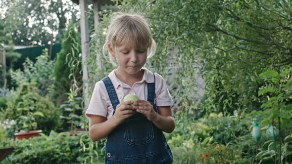Girl Eating Sour Apple in Green Garden alt