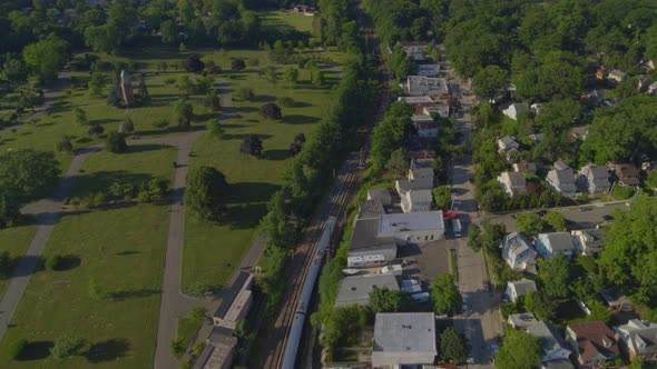 Aerial View of a Train Passing Near a Park and Suburban Neighborhood in New York