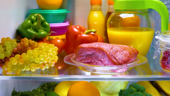 Fresh Raw Meat on a Shelf Open Refrigerator