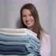 A Young Housewife Woman Holds a Stack of Fresh Washed Clean Linen in Her Hands - VideoHive Item for Sale