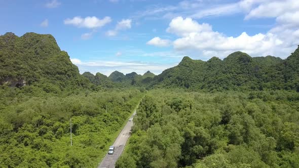 Drone Flies Over Modern Road Among Tropical Woods