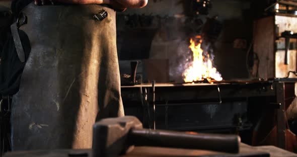 Portrait of blacksmith standing with arms crossed