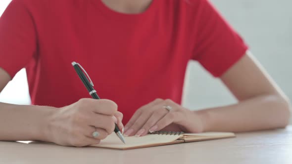 Close Up of Young Blonde Woman Writing on Notebook