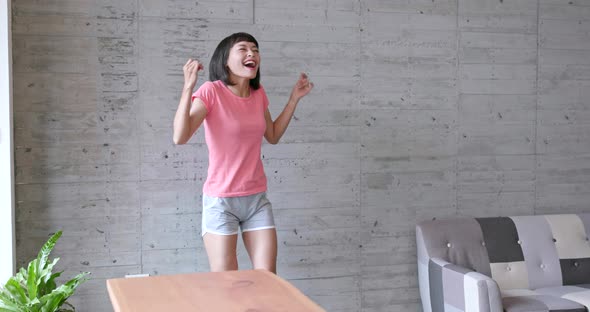 Young asian woman feeling happy and dancing at home