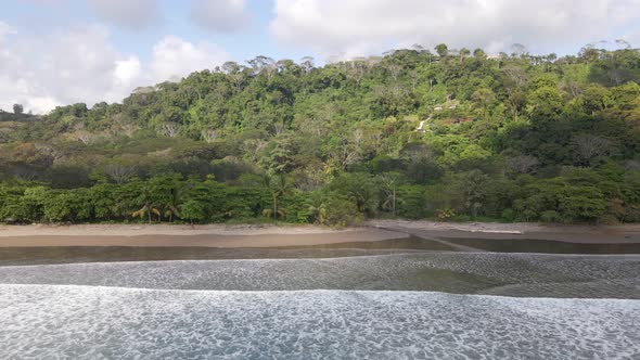 Aerial view of an almost empty beach on the west coast of Costa Rica during a sunny afternoon. Wide