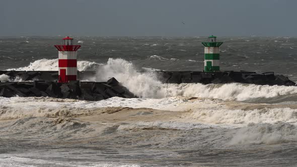 Powerful rough stormy waves crashing in promenade with lighthouse; static