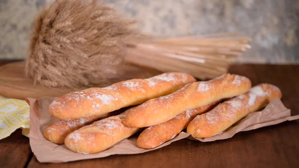 Breaking a baguette, Hands of woman breaking baked bread in half