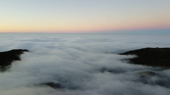 AERIAL Footage Over the Thick Fog or Clouds From Which Only the Mountain Peaks of the Blue Sky are