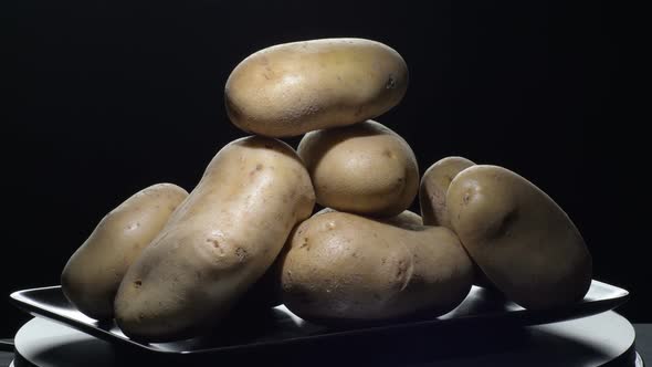 Potatoes Vegetables Gyrating on a Black Tray