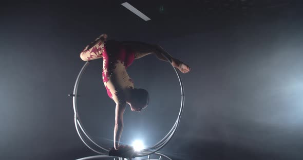 Brunette Woman is Doing an Upside Down Split in a Hoop Gymnastics