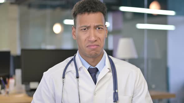 Portrait of Young Doctor Showing Thumbs Down in Office 