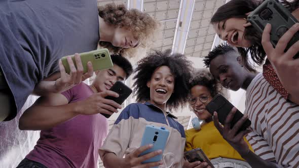 Low Angle View of a Group of Young Teenagers Holding Cell Phones