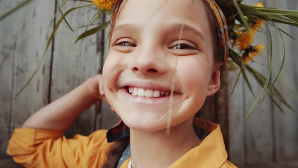 Portrait of Happy Little Girl in Flower Wreath