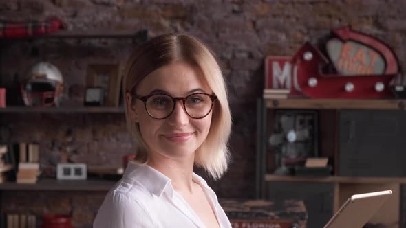 Close Up of a Young Business Woman Blonde with Glasses Reflection Portrait Looking at the Camera