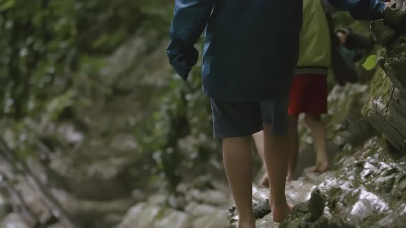 Bare Feet Walk on Wet Rocky Terrain