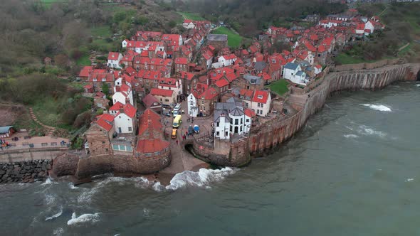 Static scenic Robin's hood bay landmark village resort houses aerial view at high tide