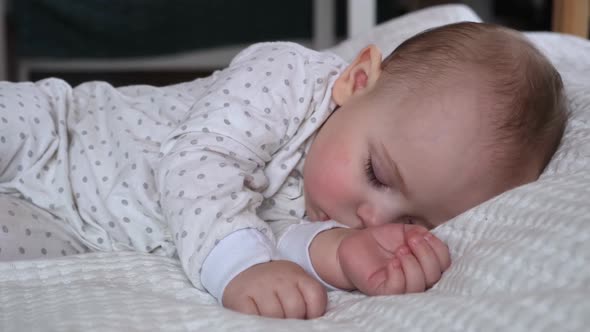 Peaceful Adorable Baby Sleeping on His Bed in a Room at Home