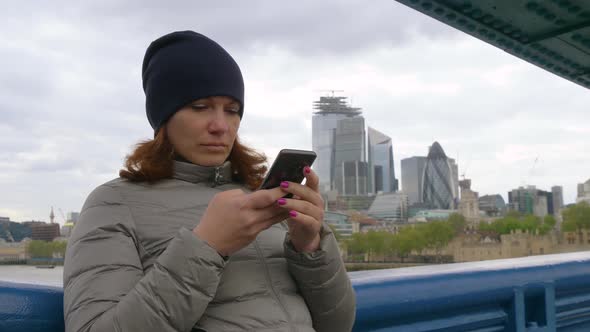 Girl Tourist Looks at the Phone in London, UK