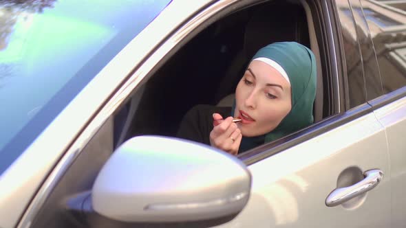 Muslim Woman in a Hijab Sits in a Car and Paints Her Lips with Lipstickslow Mo