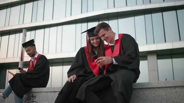 High University Graduates Rejoice at the End of Their Studies Young People in Graduate Robes are