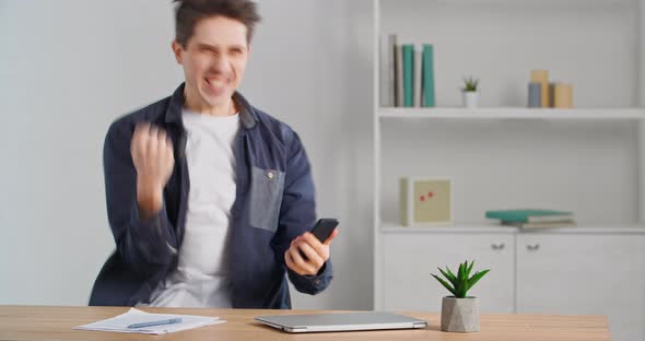 Caucasian Male Businessperson Millennial Freelancer Sitting at Desk Finishing Up Phone Call Selling