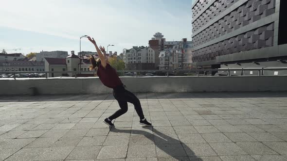 Young Female Gymnast Runs in the City and Doing a Series of Flips on Training Area Near Modern