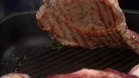 Cook frying meat steaks on grill