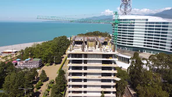 Workers And Crane On Seaside Construction