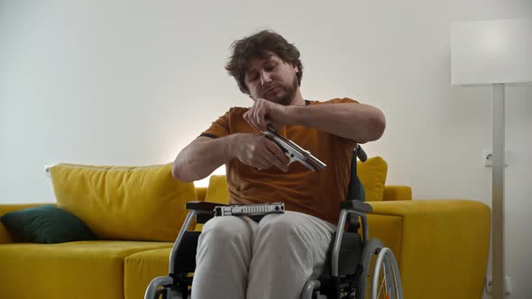 A Man in a Wheelchair Holding Guns and Pulls Back the Shutter