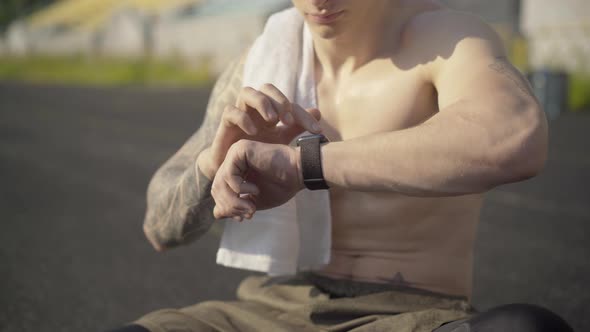 Unrecognizable Perspiring Sportsman Checking Smart Watch. Confident Fit Caucasian Man Using Online