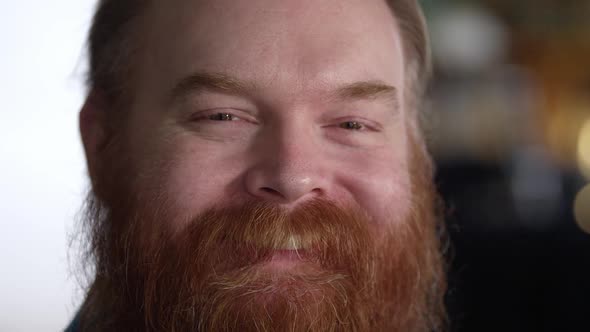 Up close to man with thick red beard as he smiles