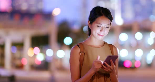 Young Woman use of smart phone in city at night