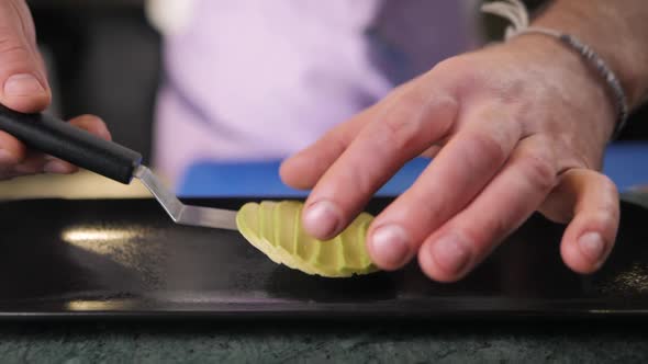 Close Up of Chef Male Hands Cooking with Avocado at Table Slice Knife Cut Macro