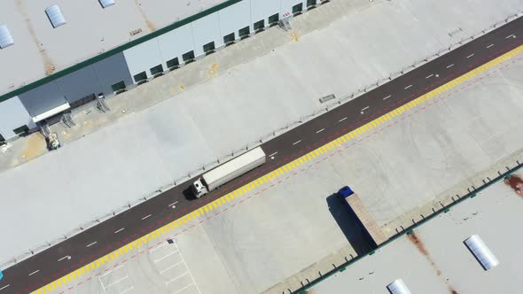 Aerial Shot of Industrial Warehouse Loading Dock where Many Truck with Semi Trailers Load Merchandis