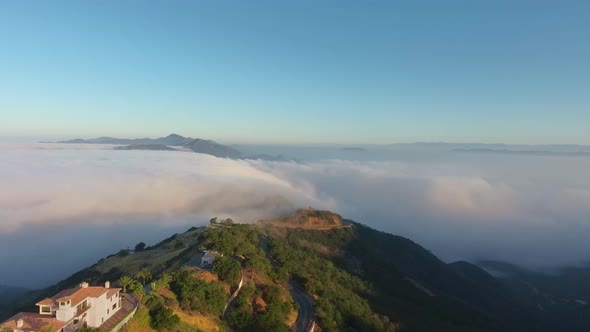Aerial shot of villas and mountain tops in the clouds (Malibu Canyon, Monte Nido, California, USA)