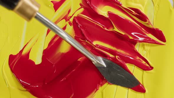Mixing Yellow and Red Paint Closeup alt