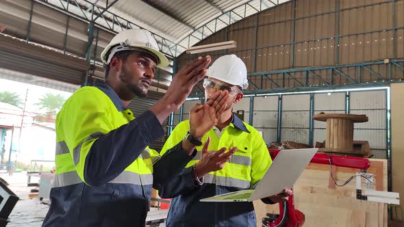 Two Engineer, Engineers Maintenance Robot Arm at manufacturing plant. Industrial Robotic Arm.