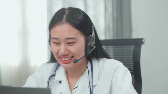 Asian Man And Woman Doctor Wearing Headsets Working As Call Centre Agent