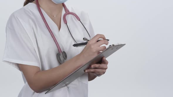 Medical personnel writing on clipboard