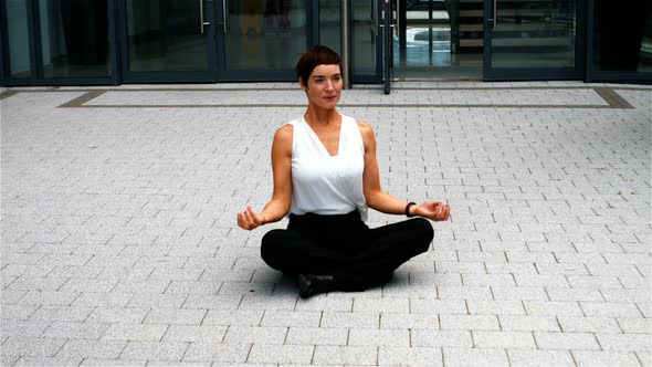 Businesswoman performing yoga