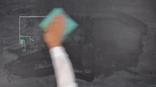 The coach of the football team erases the game plan drawn on a chalk board