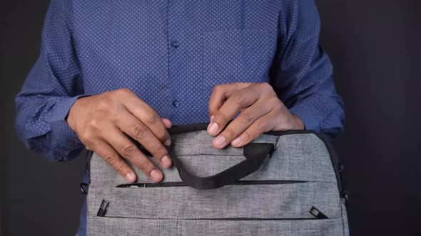 Young Man Searching Something in a Shoulder Bag