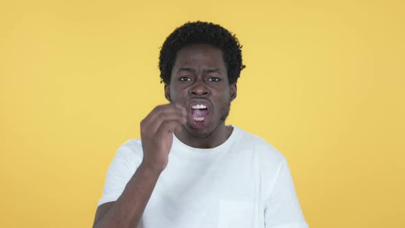 African Man with Frustration and Anger Yellow Background