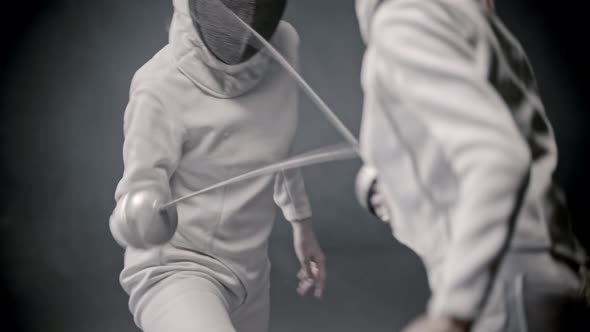 Fencing Training - Two Young Women in Protective Clothes Having a Duel Between Each Other