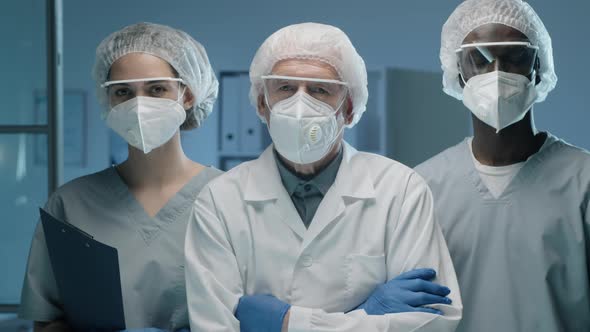 Portrait of Team of Multiethnic Lab Scientists in Protective Uniforms