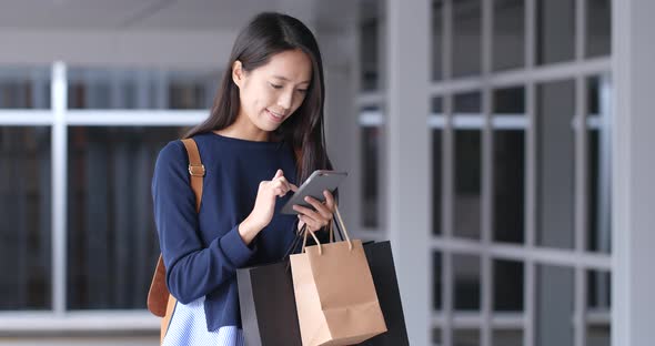 Woman look at mobile phone with shopping bag