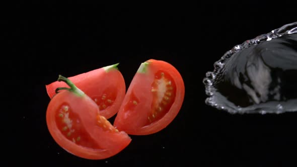 Slo-motion tomato wedges mixing with water