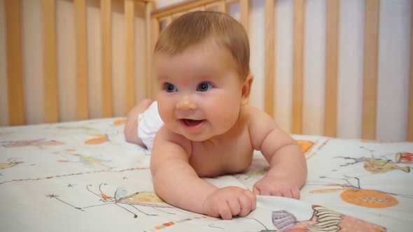 Infant In Bed Smiling Playing Cheerful